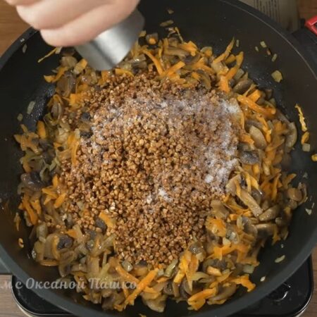 В сковороду к овощам с грибами насыпаем 1 стакан промытой гречки. Солим по вкусу и перчим черным молотым перцем. 