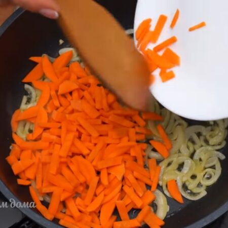 К луку добавляем подготовленную морковь. Пассеруем еще 2-3 минуты. 