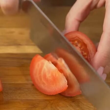 Два помидора разрезаем пополам и вырезаем место крепления плодоножки. Нарезаем их дольками.