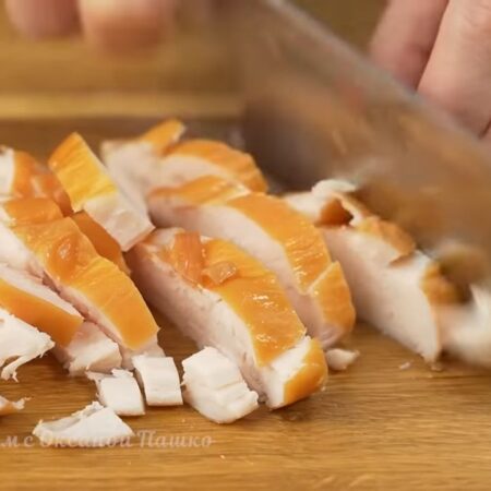 Одно копченое куриное филе сначала разрезаем вдоль на пластинки. Получившиеся пластинки режем брусочками. Вместо копченого, можно использовать жаренное или отварное куриное филе.