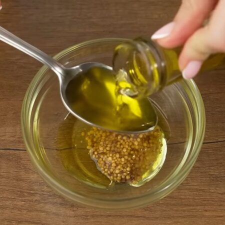Готовим соус для салата.
В небольшую мисочку насыпаем примерно пол чайной ложки соли, кладем 1 ч.л. горчицы зернами, ее можно заменить обычной горчицей. Добавляем 1 ч.л. меда, наливаем 3 ст.л. растительного масла, я использую оливковое. 
