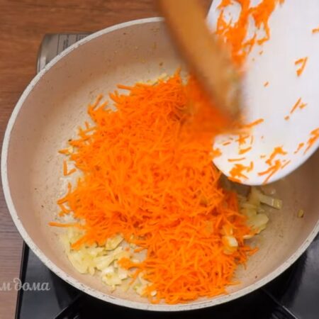 Добавляем тертую морковь. Все перемешиваем и пассеруем еще 2-3 мин.
