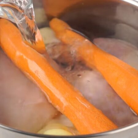 В кастрюлю кладем 1 кг помытых куриных окорочков, 500 г куриного филе, 2 очищенных морковки и одну луковицу. Все заливаем водо и ставим на огонь. 