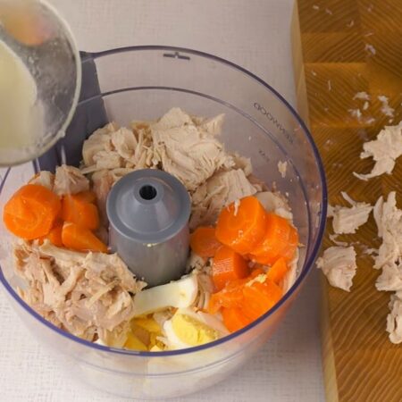 В чашу измельчителя кладем подготовленное мясо, морковь, яйца и наливаем немного бульона.