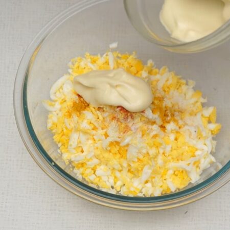  К тертым яйцам добавляем ⅓ ч. л. молотой сладкой паприки, ⅓ ч. л. карри, немного солим и добавляем 2 ст. л. майонеза. 