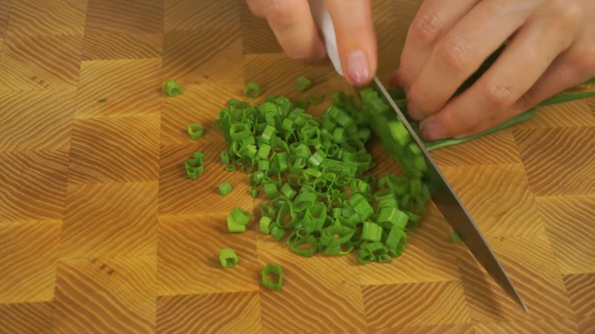 Мелко нарезаем зеленый лук и тоже высыпаем его в салат. 