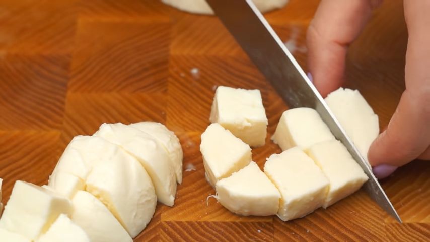 150 г сыра моцарелла нарезаем кубиками размером примерно 1.5 см.