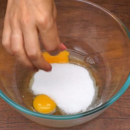 Сначала замесим тесто.
В миску разбиваем 2 яйца, насыпаем 80 г сахара и щепотку соли. 