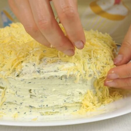 Сыр трем на мелкой терке. Тертым сыром обсыпаем весь торт сверху и по бокам. 