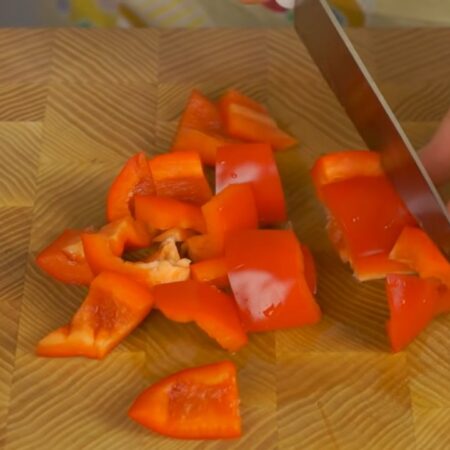 У болгарского сладкого перца вырезаем семенную коробочку и нарезаем крупными кусками. Для того, чтобы салат был более ярким можно взять по половине желтого и красного сладкого перца. 