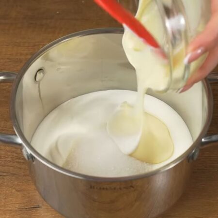 Готовим крем для торта.
В миску наливаем 500 г сметаны. Я использую сметану жирностью 15%. Насыпаем 140 г сахара и 10 г ванильного сахара. Сюда же наливаем 200 г сгущеного молока. 