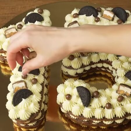 Торт украшаем кусочками печенья и разными шоколадными сладостями.