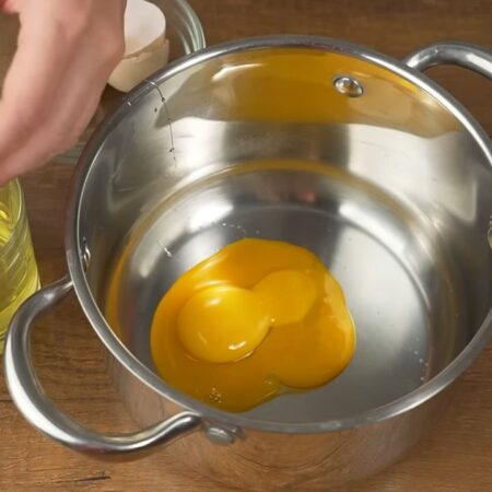 Три яйца разделяем на желток и белок. Желтки выливаем в кастрюлю, а белки нам не понадобятся.