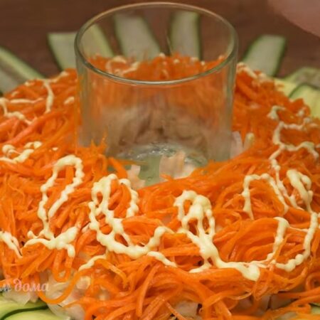Кладем морковь маринованную по корейски. Снова майонез.
Аккуратно вынимаем стакан из середины.
