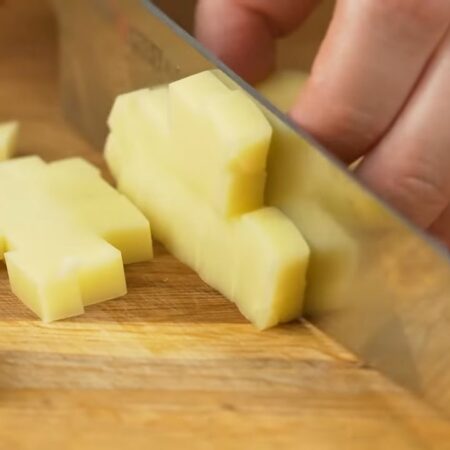 Сначала подготовим ингредиенты для начинки.
Берем 100 г сыра и нарезаем его толстыми пластинками, а затем пластинки режем небольшими кубиками.