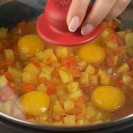 Сковороду накрываем крышкой и готовим на огне чуть меньше среднего до готовности яиц. 
