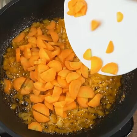 К луку добавляем нарезанную морковь. Готовим еще 2 минуты, периодически перемешивая.