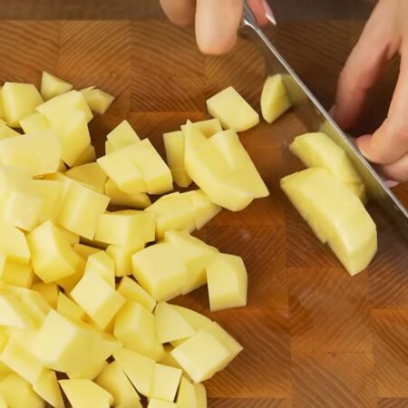 Примерно 600 г картофеля нарезаем пластинками толщиной около 1 сантиметра, а затем режем кубиками.