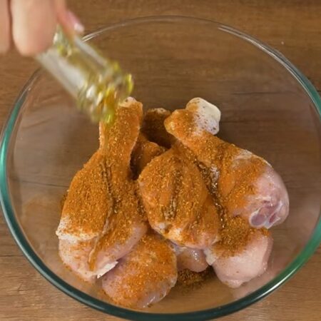 Сначала подготовим мясо.
В миску кладем 8 штук уже помытых куриных ножек. Солим их по вкусу. Насыпаем 1 столовую ложку приправы для курицы. Наливаем немного растительного масла. 