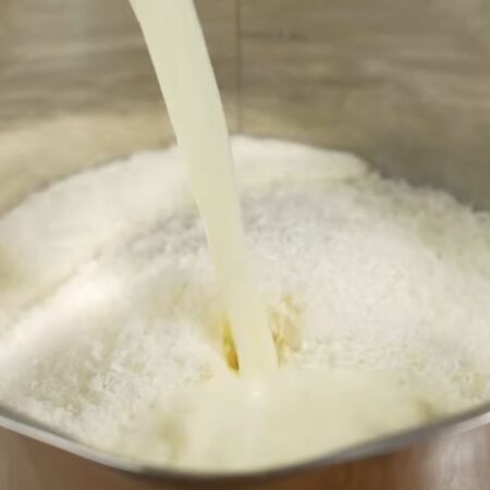 В кастрюлю насыпаем 1 стакан манки, это 180 г, также насыпаем 150 г сахара и 50 г кокосовой стружки. Сюда же наливаем 1 литр молока. 