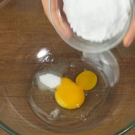 Сначала приготовим тесто.
В миску разбиваем 1 яйцо, насыпаем 10 г ванильного сахара и щепотку соли. Сюда же добавляем 130 г сахарной пудры.