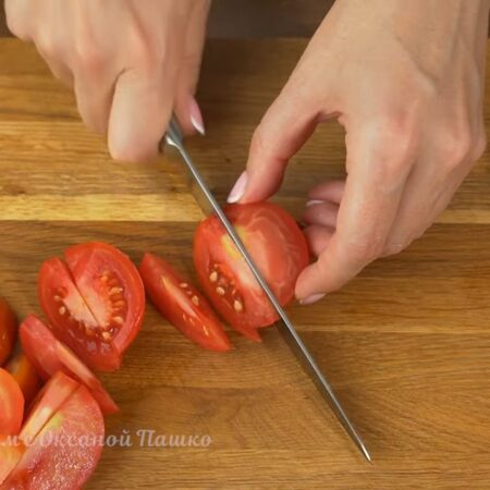 Берем примерно пол килограмма помидоров, разрезаем их пополам и вырезаем плодоножку. Половинки помидоров нарезаем дольками.