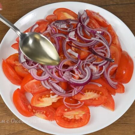 Складываем салата.
На большое плоское блюдо выкладываем нарезанные дольками помидоры. Равномерно распределяем их по блюду.
Сверху кладем лук. Разделяем его руками на более мелкие части. Вместо красного лука можно использовать белый.