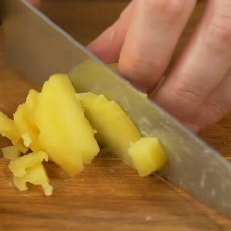 Три средних вареных картошки нарезаем пластинками, а затем получившиеся пластинки режем небольшими кубиками.