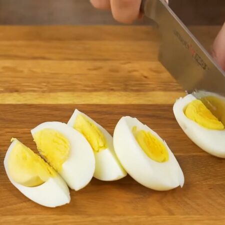 Вареные яйца разрезаем вдоль на 4 части. Для салата понадобится 2 яйца.