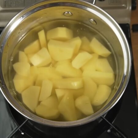 Подготовленный картофель кладем в кастрюлю. Заливаем водой и ставим на плиту. Воду солим и варим картофель до полной готовности.
