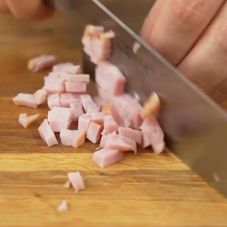 Ветчину нарезаем сначала кружочками, а затем получившиеся кружочки режем маленькими кубиками. Ветчину можно заменить вареной колбасой и натереть ее на крупной терке. Также можно использовать любое уже готовое мясо.