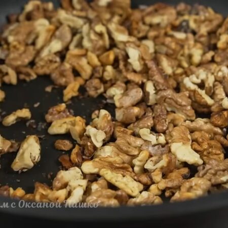 Готовим ингредиенты для начинки.
120 г грецких орехов выкладываем на сковороду. Обжариваем орехи на небольшом огне примерно 10 минут, периодически перемешивая. Готовые орехи снимаем с плиты и даем им немного остыть.