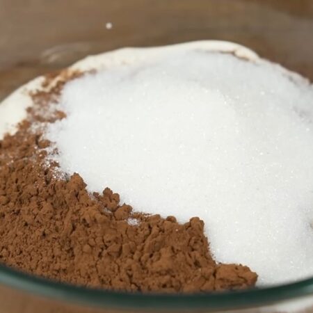 Готовим крем для торта.
В миску наливаем 600 мл сметаны, насыпаем 30 г какао и 100 г сахара.