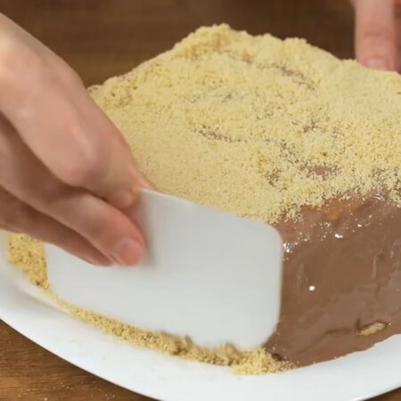 Приготовленной крошкой посыпаем торт сверху и по бокам. Для посыпки сбоку удобно использовать небольшой шпатель или силиконовую лопатку.