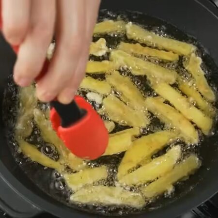 В разогретое масло выкладываем подготовленную картошку. Кладем по одному брусочку. Таким методом заполняем всю сковороду. Жарим картошку примерно 7 минут до красивой румяной корочки.
