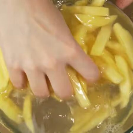 Нарезанный картофель перекладываем в миску. Все заливаем водой. Картошку моем от крахмала, а воду сливаем.