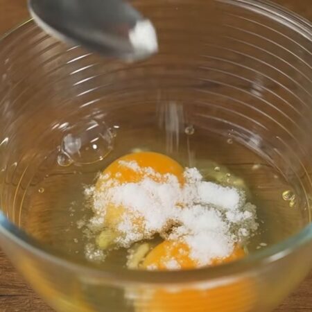 В отдельную небольшую мисочку разбиваем 2 яйца. Насыпаем 0,5 чайной ложки соли