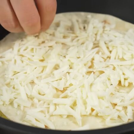 На разогретую сковороду с небольшим количеством растительного масла кладем приготовленную лепешку. Сверху посыпаем ее тертым сыром.