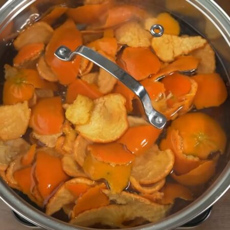 Уже промытые мандариновые шкурки кладем в кастрюлю и заливаем водой. Накрываем крышкой и ставим на плиту. 