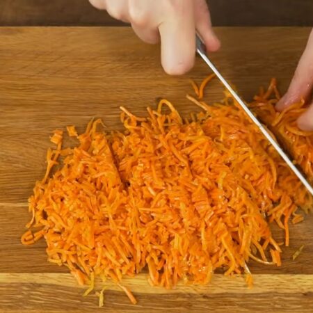 Берем 150 г моркови по-корейски и нарезаем ее на более мелкие кусочки.