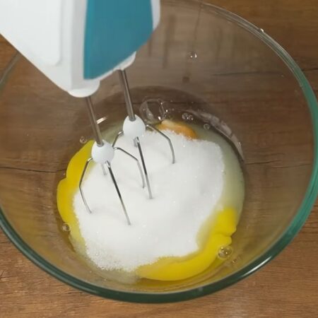 Сначала приготовим бисквит.
В миску разбиваем 2 яйца, насыпаем 150 г сахара.
