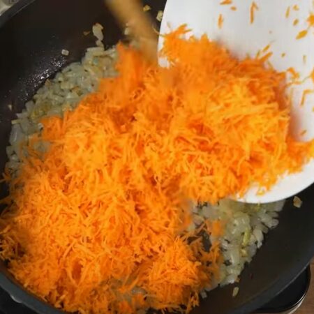 Сюда же кладем тертую морковь. Перемешиваем и готовим до мягкости морковки.