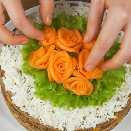 Приготовленные морковные цветы выкладываем по центру на листья салата.