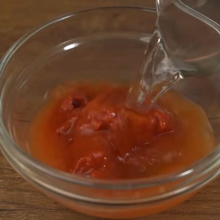 Берем 2 столовых ложки томатной пасты и наливаем к ней примерно 100-150 мл воды, перемешиваем.