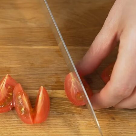 Один помидор черри разрезаем сначала на 4 части. А затем каждую дольку разрезаем еще на две части.