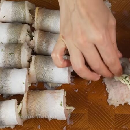 Каждый кусочек рыбы скручиваем в рулет. Начинаем скручивать рулет с более широкой стороны.