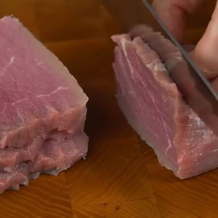 300 г мяса нарезаем сначала на пластинки поперек волокон, а затем брусочками. 
