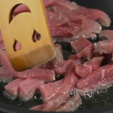 Нарезанное мясо выкладываем на горячую сковороду с растительным маслом. 