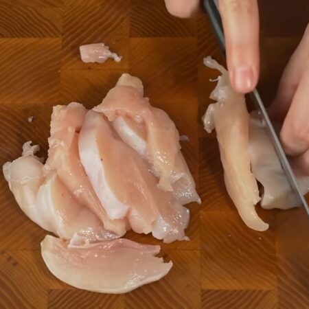 Одно куриное филе нарезаем длинными кусочками.